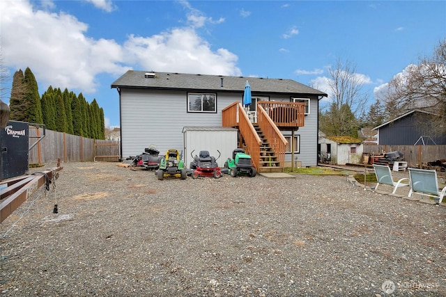 back of property with fence, stairway, and a wooden deck