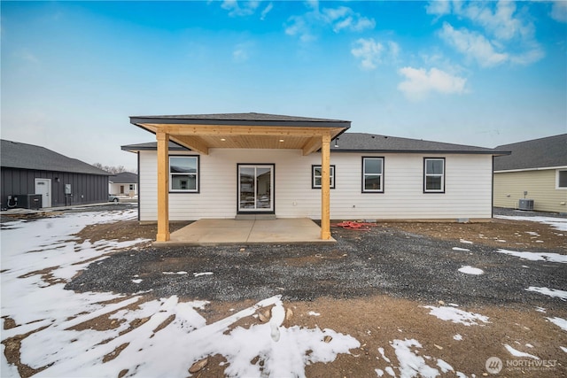 snow covered house with a patio area and cooling unit