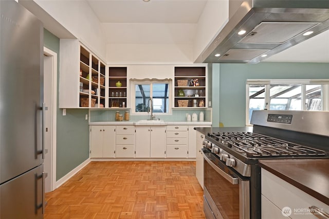 kitchen with appliances with stainless steel finishes, white cabinetry, open shelves, a sink, and exhaust hood