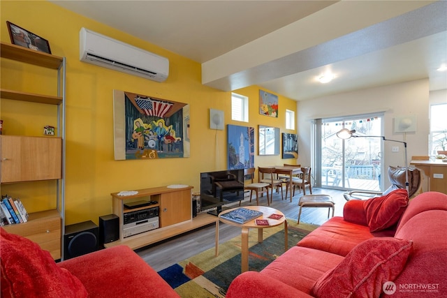 living area with a wall mounted air conditioner and wood finished floors