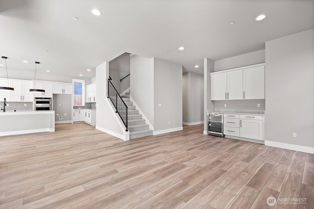 1424 238th St SE, Bothell, WA 98021 - unfurnished living room featuring stairway, light wood-style flooring, recessed lighting, and beverage cooler