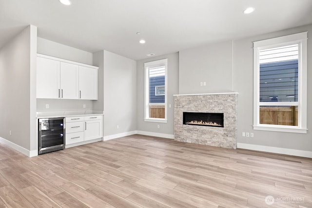 1424 238th St SE, Bothell, WA 98021 - unfurnished living room with beverage cooler, baseboards, recessed lighting, and light wood-type flooring