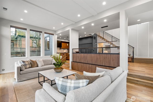 living area with light wood finished floors, baseboards, visible vents, stairs, and recessed lighting