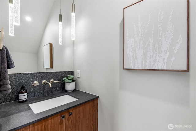 bathroom featuring lofted ceiling and vanity