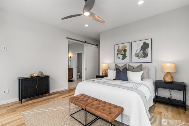 bedroom featuring baseboards, a barn door, recessed lighting, and light wood-style floors