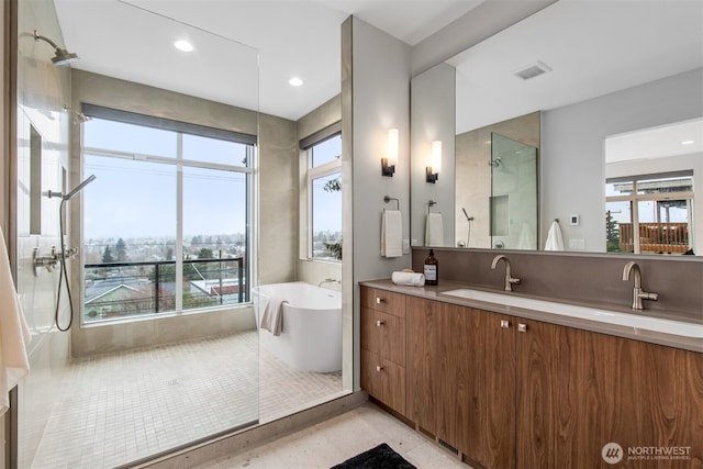 full bath featuring double vanity, visible vents, a freestanding bath, a sink, and a shower stall