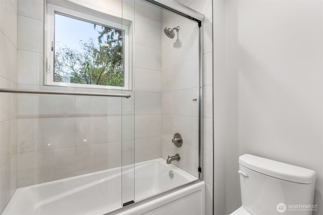 bathroom featuring enclosed tub / shower combo and toilet