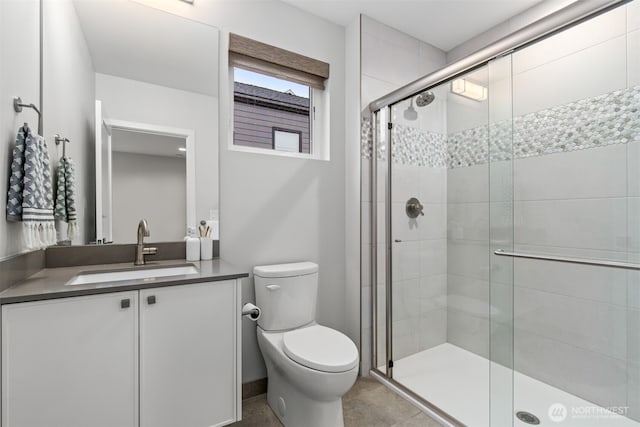 bathroom featuring a stall shower, vanity, and toilet