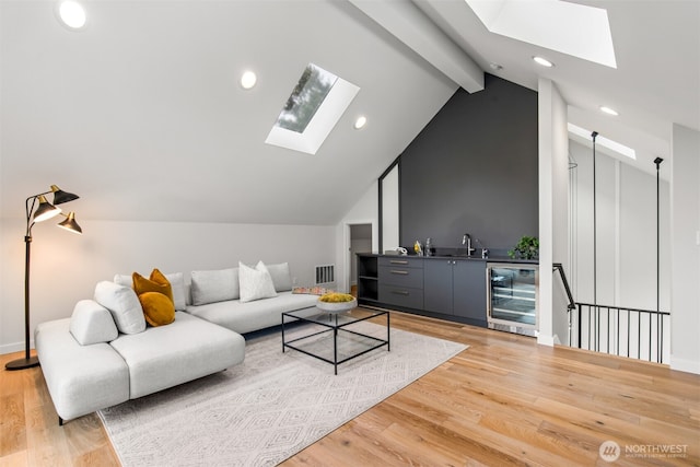 living room with vaulted ceiling with beams, wine cooler, light wood-style flooring, visible vents, and wet bar