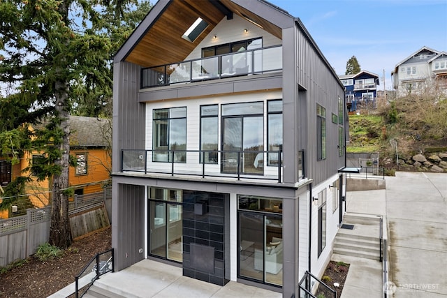 rear view of property featuring fence and a balcony