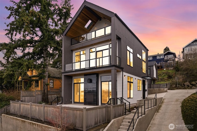 back of property at dusk featuring stairway and fence