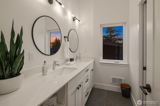 bathroom with double vanity, visible vents, tile patterned floors, and a sink