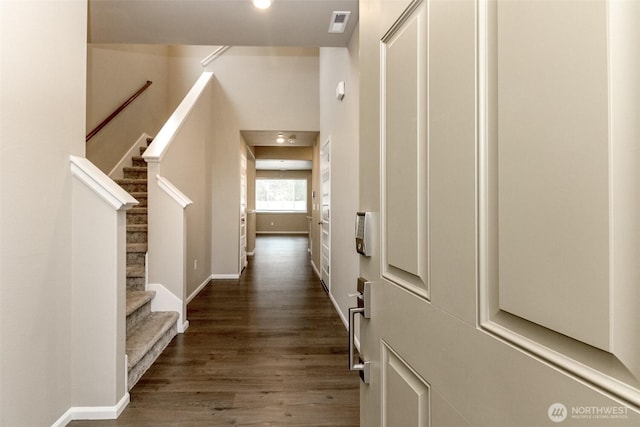 foyer featuring visible vents, stairs, baseboards, and dark wood-type flooring