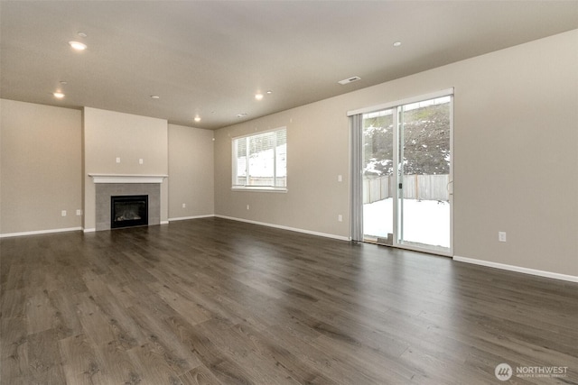 unfurnished living room with dark wood-style flooring and baseboards