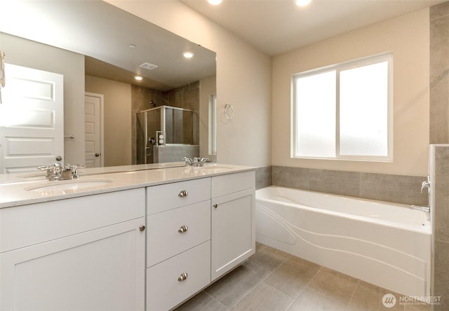 bathroom featuring a garden tub, double vanity, a stall shower, a sink, and tile patterned floors