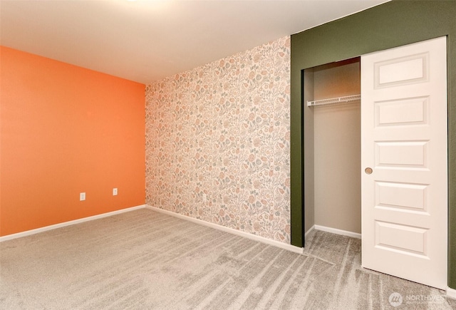 unfurnished bedroom with a closet, carpet, and baseboards