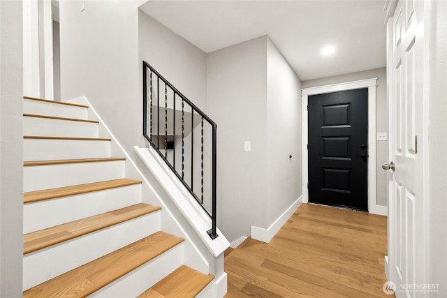 entrance foyer featuring light wood-style flooring, stairs, and baseboards