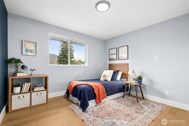 bedroom with light wood-style floors and baseboards