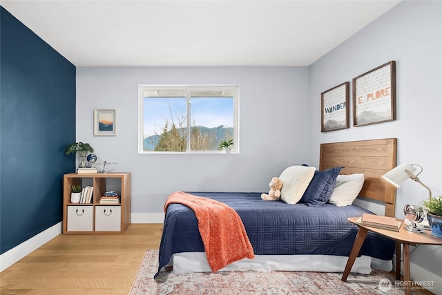 bedroom with light wood-type flooring and baseboards