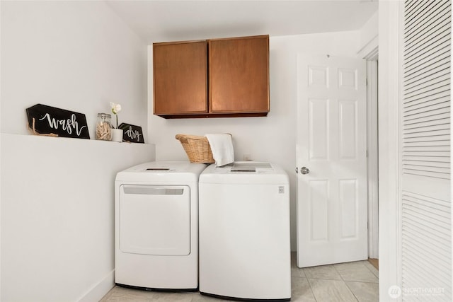 laundry room featuring separate washer and dryer, light tile patterned flooring, and cabinet space