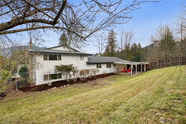 back of house with a patio, a lawn, and fence