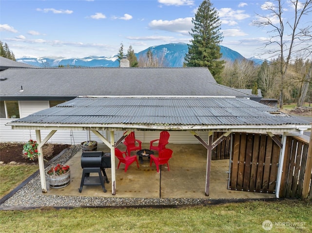 exterior space featuring a patio area, an outdoor fire pit, and a mountain view