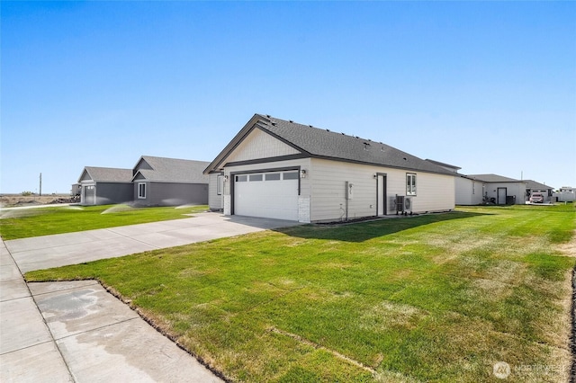 view of side of property featuring an attached garage, a yard, and driveway