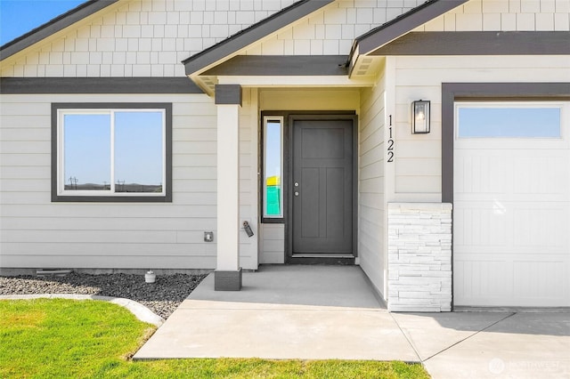 view of exterior entry featuring an attached garage