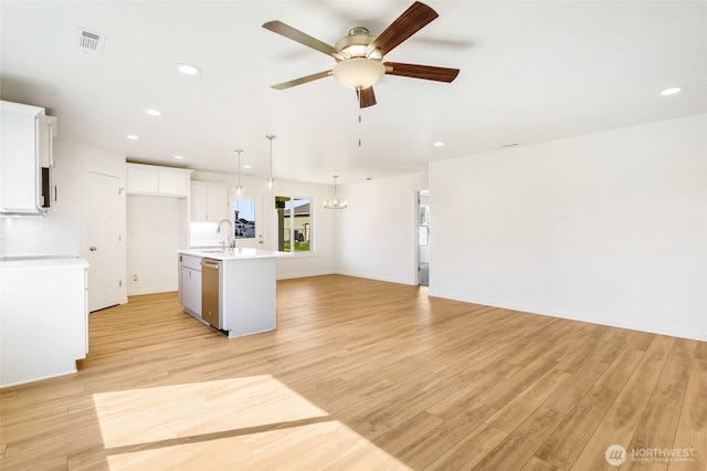 kitchen with stainless steel dishwasher, open floor plan, an island with sink, recessed lighting, and ceiling fan with notable chandelier