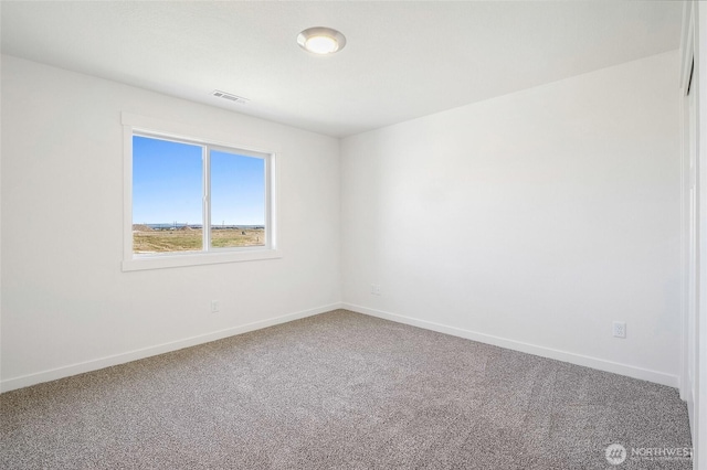 carpeted spare room with visible vents and baseboards