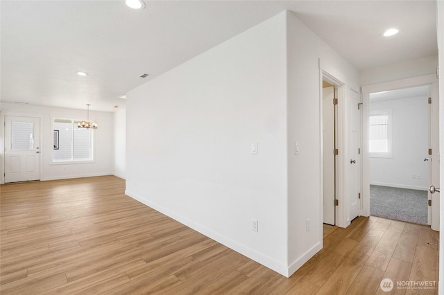 interior space with an inviting chandelier, baseboards, recessed lighting, and light wood-style flooring