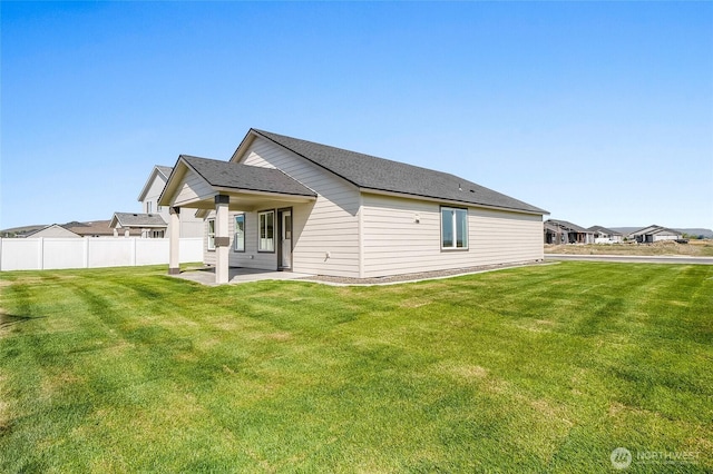 back of house featuring a lawn, fence, and a patio area
