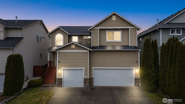 craftsman-style home with a garage, stone siding, stairs, and concrete driveway