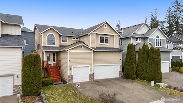 craftsman-style home featuring a shingled roof, concrete driveway, stone siding, an attached garage, and stairs