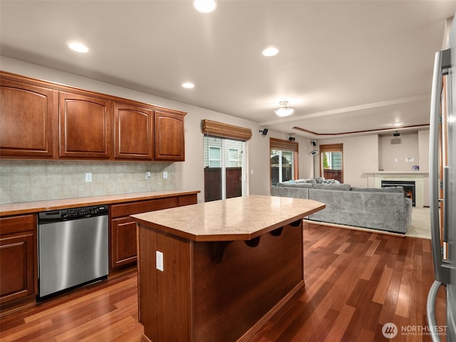 kitchen featuring dark wood-style flooring, light countertops, a kitchen island, and stainless steel dishwasher