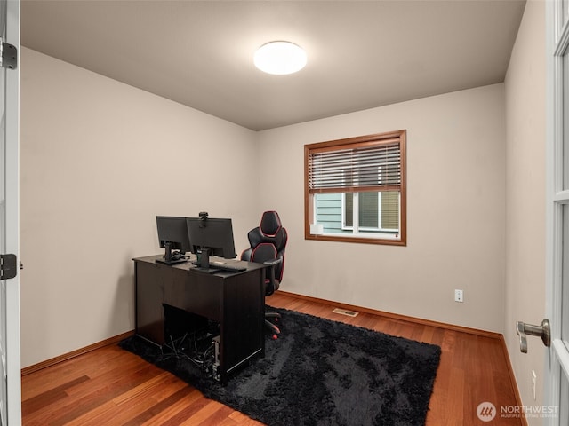 home office featuring visible vents, baseboards, and wood finished floors