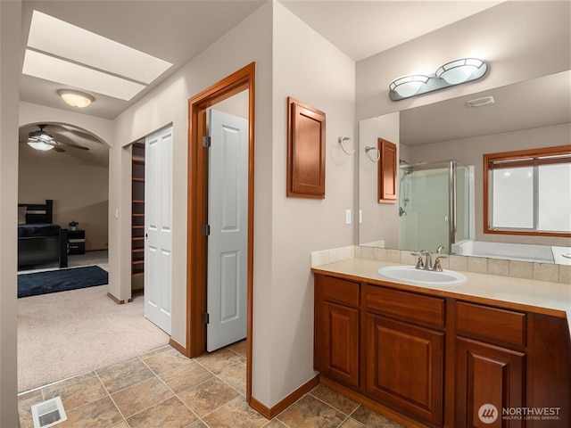 bathroom with ceiling fan, vanity, visible vents, baseboards, and a shower stall