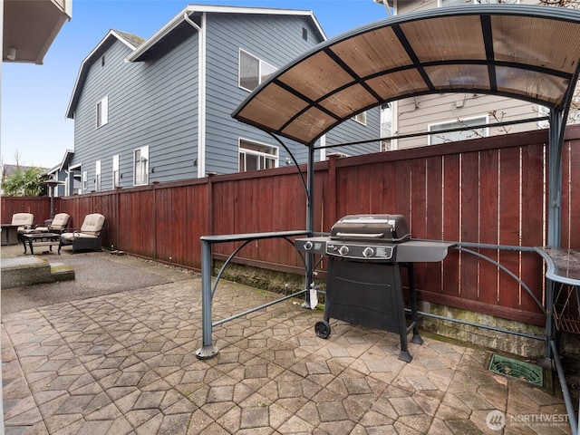 view of patio with area for grilling and fence