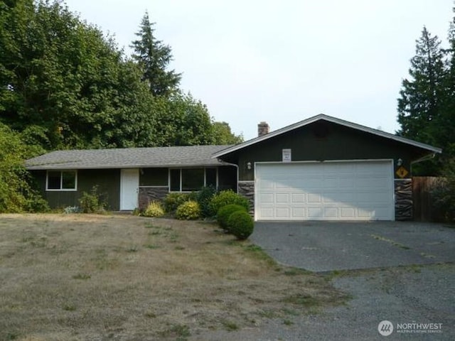 ranch-style house with aphalt driveway and a garage