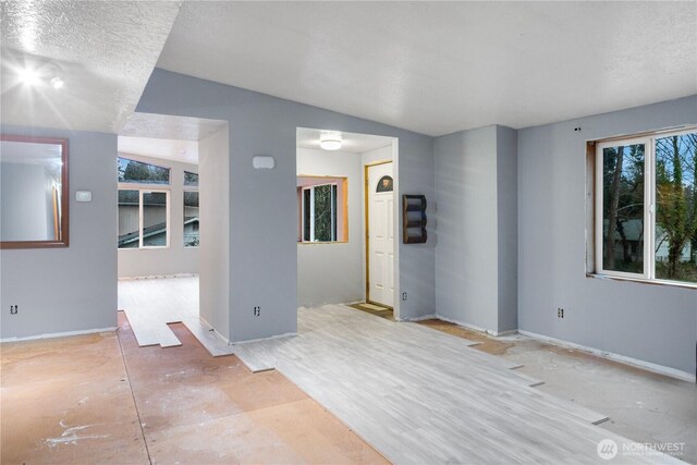 6612 NE Pear St, Suquamish, WA 98392 - spare room featuring lofted ceiling, a textured ceiling, and baseboards