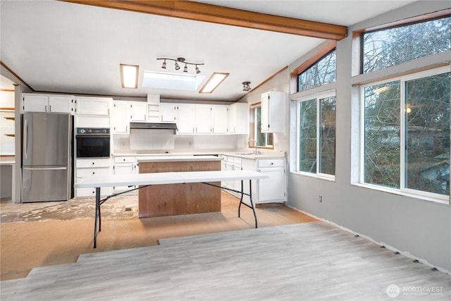 6612 NE Pear St, Suquamish, WA 98392 - kitchen with vaulted ceiling with beams, oven, white cabinetry, light countertops, and freestanding refrigerator