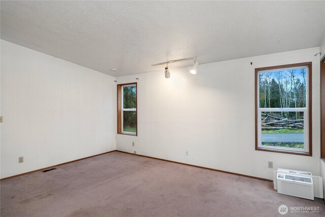 6612 NE Pear St, Suquamish, WA 98392 - carpeted spare room featuring a textured ceiling, a wall mounted air conditioner, visible vents, and baseboards