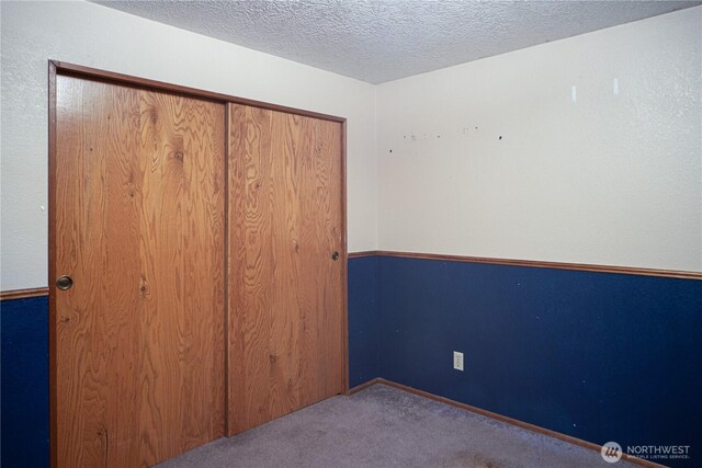6612 NE Pear St, Suquamish, WA 98392 - unfurnished bedroom with light carpet, a closet, and a textured ceiling
