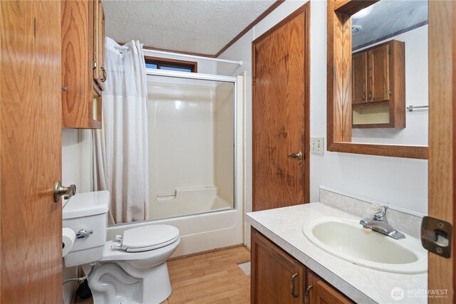 6612 NE Pear St, Suquamish, WA 98392 - bathroom with a textured ceiling, toilet, shower / bath combination with glass door, wood finished floors, and vanity