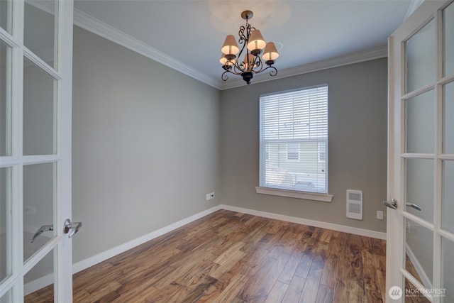 spare room featuring french doors, wood finished floors, an inviting chandelier, and ornamental molding