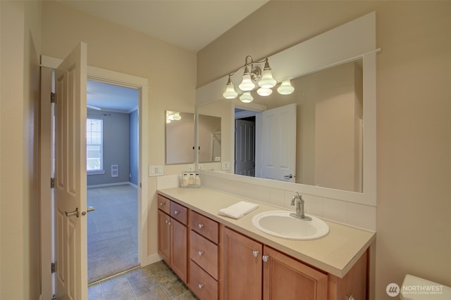 bathroom featuring a chandelier, vanity, and baseboards