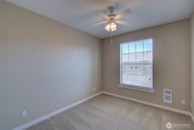 spare room with heating unit, light colored carpet, baseboards, and ceiling fan