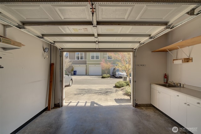 garage with a sink and baseboards