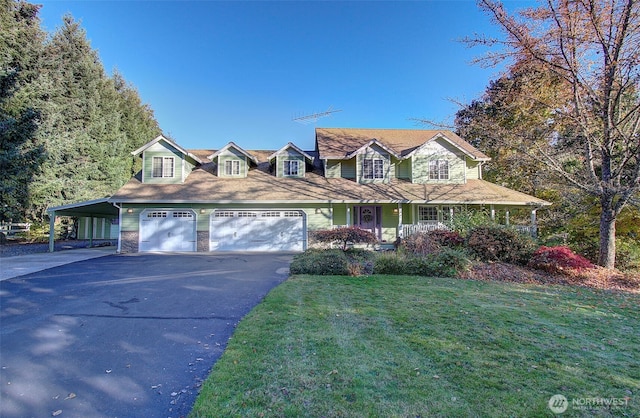 view of front of home with a front yard, stone siding, driveway, and an attached garage