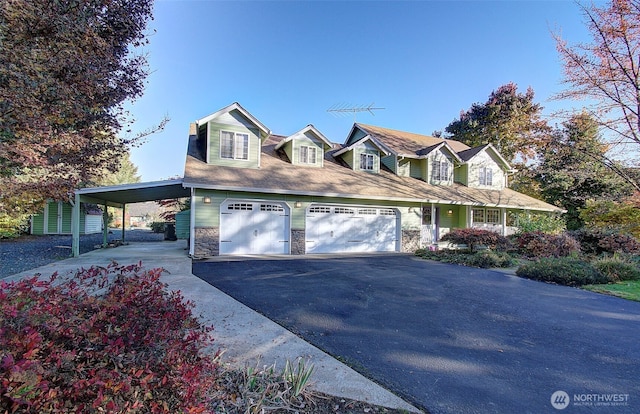 cape cod-style house with a garage, driveway, a carport, and stone siding